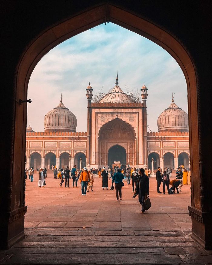 Stunning view of a historic mosque courtyard filled with tourists, showcasing architectural splendor.